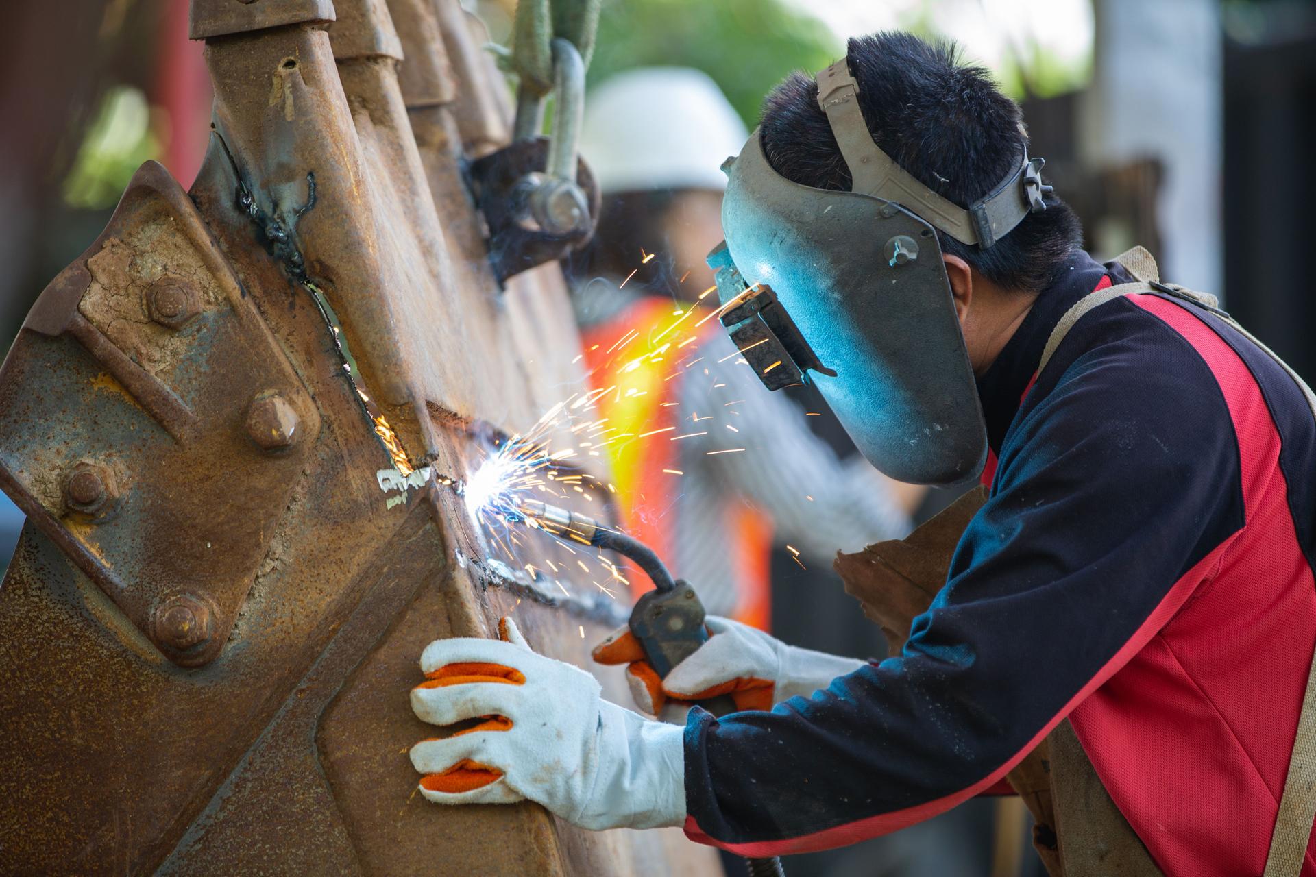 Specialist welder weld construction frame, welding spark , Welder is welding metalwork manufacturing and construction maintenance service.