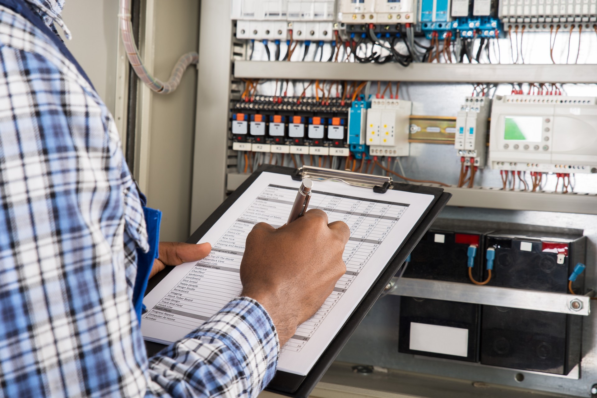 Male Technician Writing On Clipboard